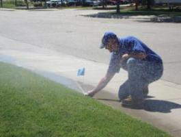 a Pompano Beach FL sprinkler repair professional is checking a newly installed sprinkler head